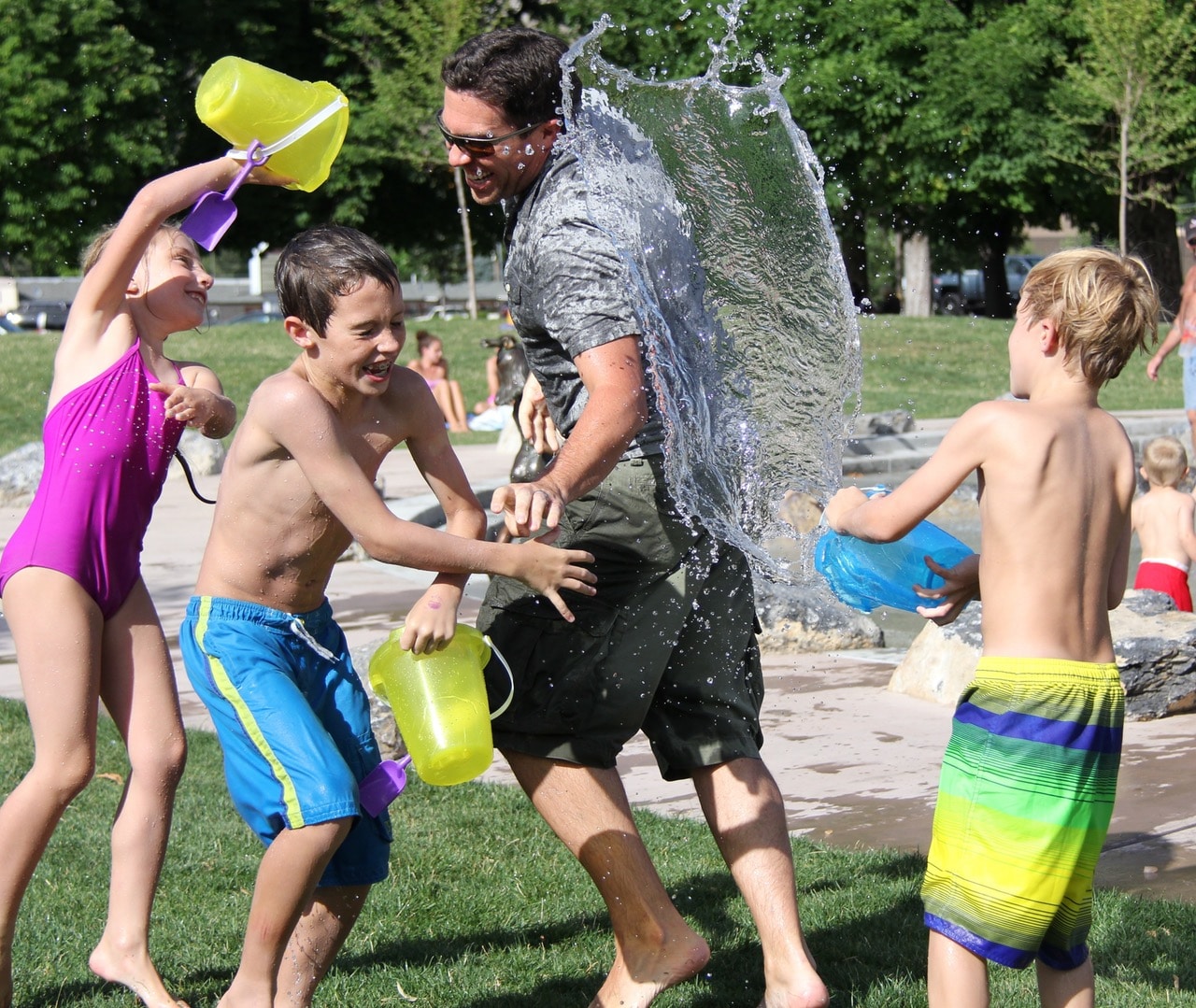 father-having-water-fight-with-children